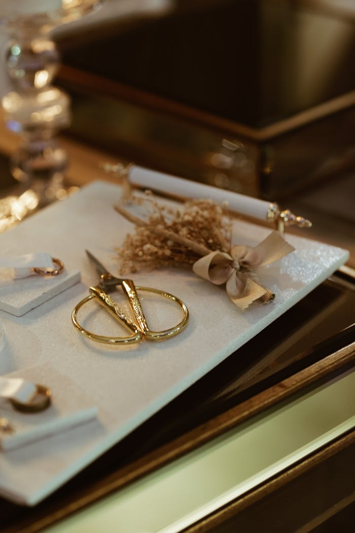 The Art of Drawing Readers In: Your attractive post title goes here Stylish arrangement of gold scissors, dried flowers, and vintage accessories on a reflective tray.