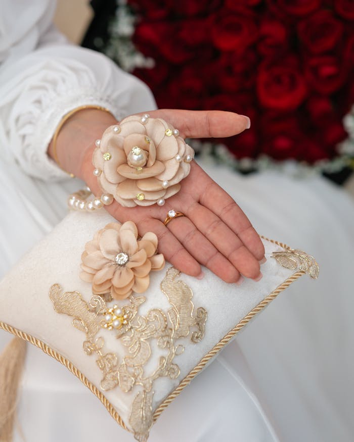 About Close-up of an engagement ring on a decorative cushion with white and beige floral design in Tunisia.